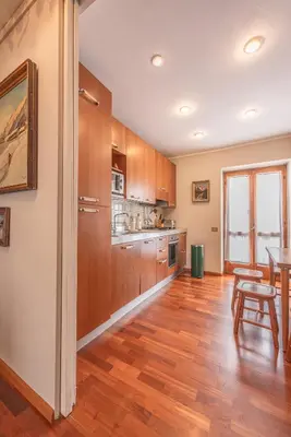 a kitchen with wooden cabinets and a table in it at Casa Carina in Cortina d Ampezzo in Cortina dʼAmpezzo