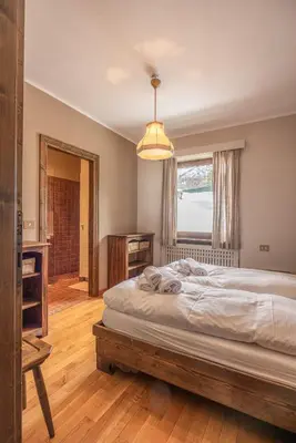 a bedroom with a large bed and a window at Casa Carina in Cortina d Ampezzo in Cortina dʼAmpezzo
