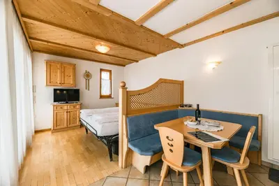a room with a desk and a bed and a table at Apartments Scherlin in Castelrotto