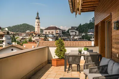 a balcony with a table and chairs and a view of a city at Apartments Scherlin in Castelrotto