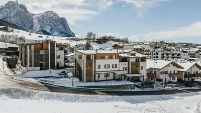 a town in the snow with houses and mountains at Apartments Scherlin in Castelrotto