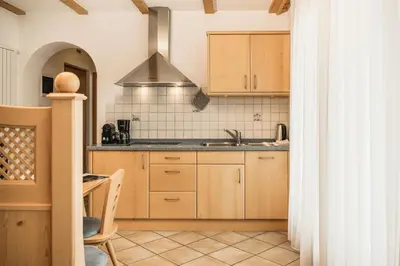 a kitchen with wooden cabinets and a sink at Apartments Scherlin in Castelrotto