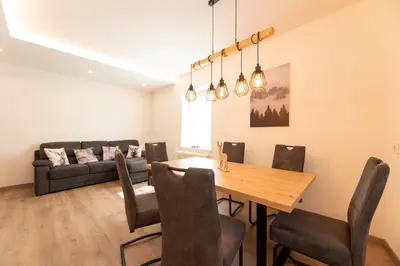 a dining room with a table and a couch at Casa di Gio in Cavalese
