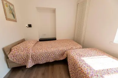 a small bedroom with two beds and a window at Casa di Gio in Cavalese