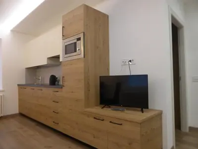 a television on a wooden cabinet in a room at Casa di Gio in Cavalese