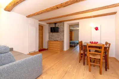 a living room with a table and a couch at Appartamento Focobon in Falcade