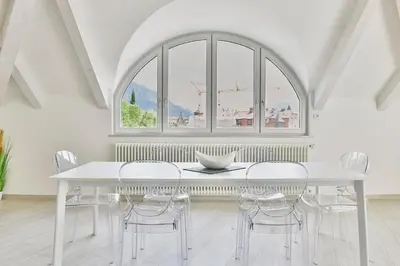 a white dining room with a white table and chairs at Eden House Experience in Merano