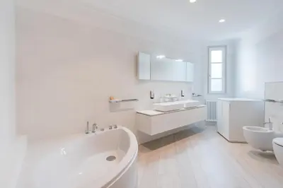 a white bathroom with two sinks and a tub at Eden House Experience in Merano