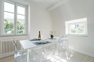 a white dining room with a white table and chairs at Eden House Experience in Merano