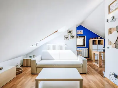 a living room with a white couch and a blue wall at Apartment Mansarda Golfieri by Interhome in Alba di Canazei