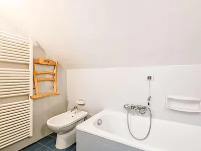 a bathroom with a toilet and a tub and a sink at Apartment Mansarda Golfieri by Interhome in Alba di Canazei