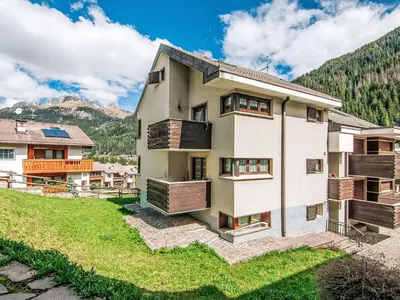 a house in the mountains with a green yard at Apartment Mansarda Golfieri by Interhome in Alba di Canazei