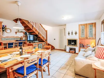 a kitchen and living room with a table and a couch at Apartment Condominio Parco degli abeti by Interhome in Canazei