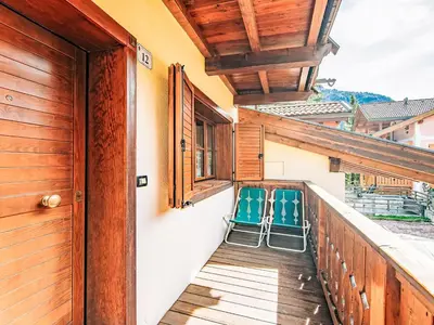 a balcony with two blue chairs on it at Apartment Condominio Parco degli abeti by Interhome in Canazei
