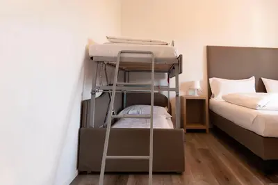 a dining room with a table and a bathroom at Roma Ariston 10 in Bolzano