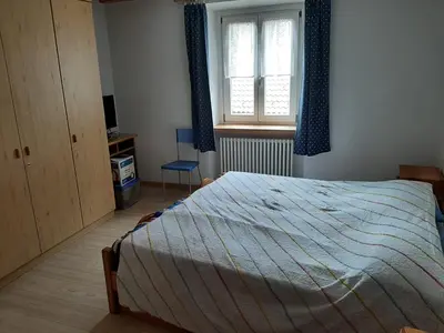 a bedroom with a bed and a window at Accogliente Bilocale in centro a Predazzo in Predazzo