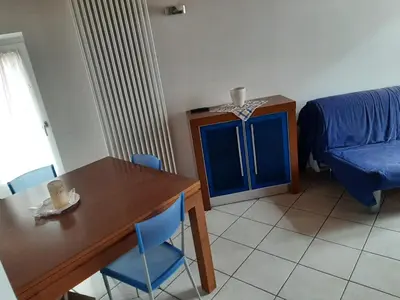 a dining room with a table and a blue cabinet at Accogliente Bilocale in centro a Predazzo in Predazzo