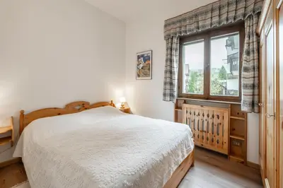 a bedroom with a bed and a window at Lovely 2 bedroom flat in Corso Italia with parking in Cortina dʼAmpezzo