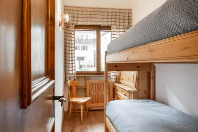 a bedroom with a bunk bed and a window at Lovely 2 bedroom flat in Corso Italia with parking in Cortina dʼAmpezzo