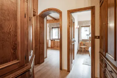 a hallway with a mirror and a room with a table at Lovely 2 bedroom flat in Corso Italia with parking in Cortina dʼAmpezzo