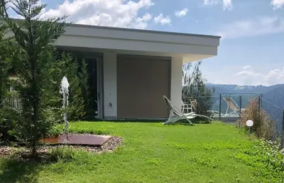 a house with a fountain in a yard at Chalet Tschattlhof Dolomites in Ponte Nova