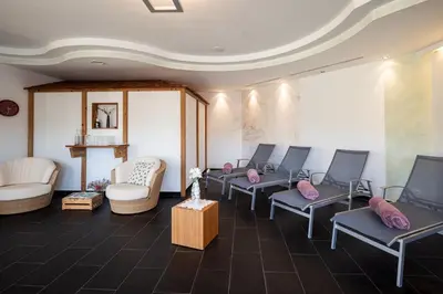 a waiting room with blue chairs and pink pillows at Garni Jasmin in Kastelruth