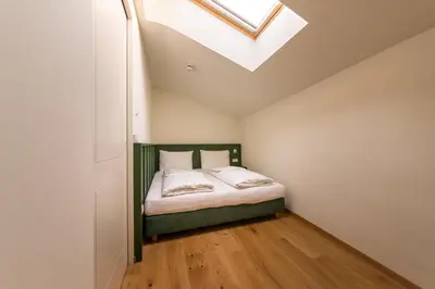 a small bedroom with a bed with a skylight at Casa Fellin Guesthouse in Vipiteno