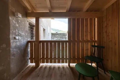 a room with a green chair and a window at Casa Fellin Guesthouse in Vipiteno