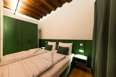 a large bed in a room with green walls at Casa Fellin Guesthouse in Vipiteno