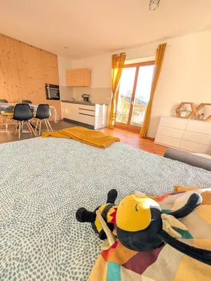 a stuffed animal laying on a bed in a room at Appartamento LA REGINA un dolce rifugio tra api e natura in Tret