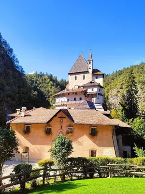 a large building on top of a hill with a castle at Appartamento LA REGINA un dolce rifugio tra api e natura in Tret