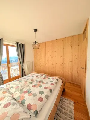 a bedroom with a bed with a quilt on it at Appartamento LA REGINA un dolce rifugio tra api e natura in Tret