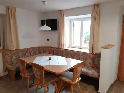 a table and chairs in a living room with a couch at Neuhäusel-Hof Appartments in Avigna