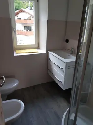 a bathroom with a sink and a window at Neuhäusel-Hof Appartments in Avigna