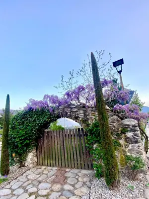 a wooden gate with purple flowers and a fence at Appartement Primula - Haus Midi in Marlengo