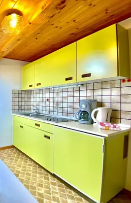 a kitchen with green counters and yellow cabinets at Appartement Primula - Haus Midi in Marlengo