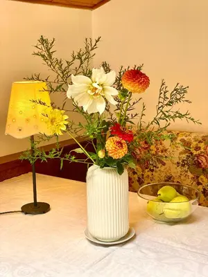 a white vase filled with flowers on a table at Appartement Primula - Haus Midi in Marlengo