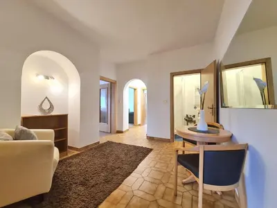 a living room with a table and a couch at Urlaub auf dem Bauernhof Schmidhof - große Terrasse, Pool und beste Lage in Caldaro