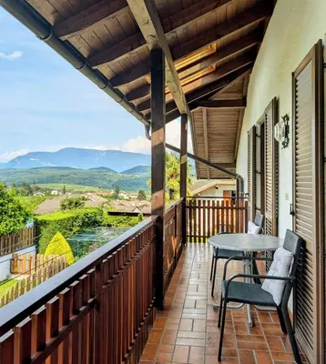 a balcony with a table and chairs and a view at Urlaub auf dem Bauernhof Schmidhof - große Terrasse, Pool und beste Lage in Caldaro