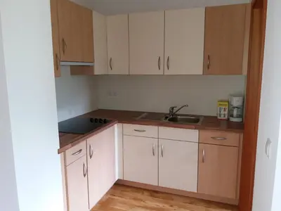 a kitchen with white cabinets and a sink at Gasthof Alpenrose - Mühleben in Sarntal