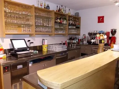 a kitchen with a bar with a counter top at Gasthof Alpenrose - Mühleben in Sarntal