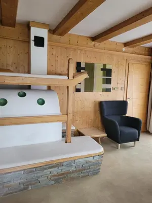 a room with a chair and a table and a shelf at Ferienwohnung Pfitschtal in San Giacomo Val di Vizze