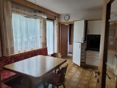 a kitchen with a table and a table and a refrigerator at Ferienwohnung Pfitschtal in San Giacomo Val di Vizze