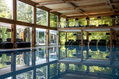 a house with a pool with chairs in it at Hotel Villa Irma in Merano