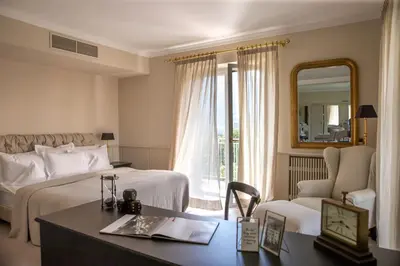 a hotel room with a bed and a desk and a mirror at Hotel Villa Irma in Merano