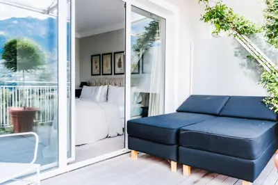 a living room with a couch and a bed on a balcony at Hotel Villa Irma in Merano
