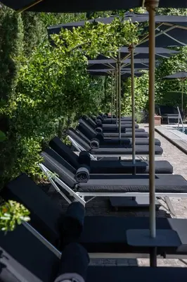 a row of benches with umbrellas at Hotel Villa Irma in Merano