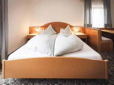 a bedroom with a large bed with white pillows at Prissianerhof in Tesimo