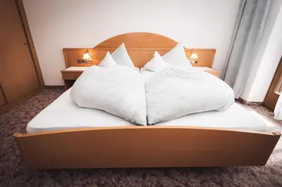 a bed with white pillows on top of it at Prissianerhof in Tesimo