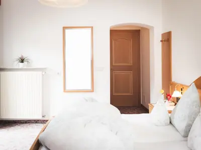 a bedroom with a bed with white sheets and a window at Prissianerhof in Tesimo